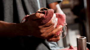 A man wiping his hand with a red cloth