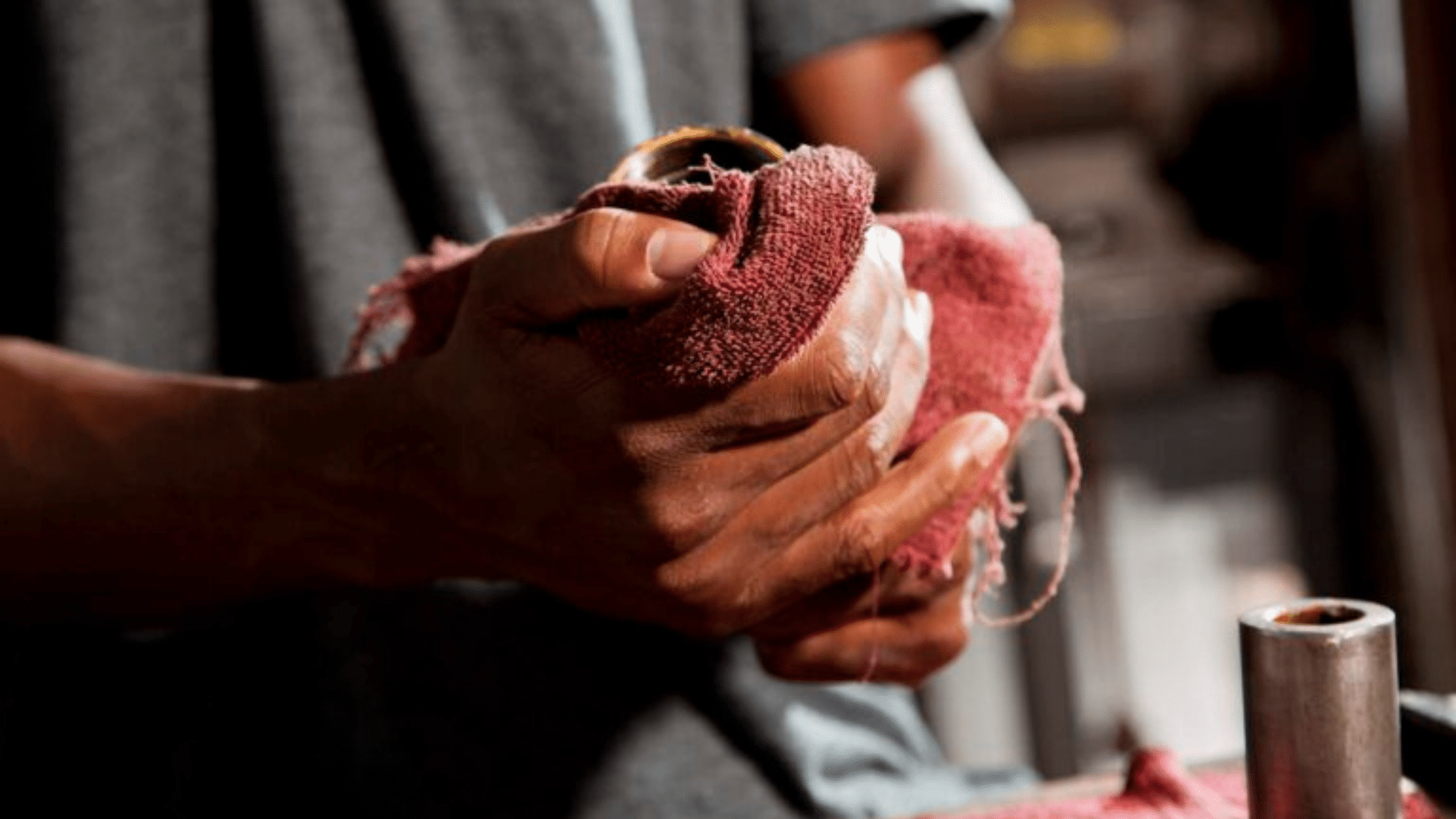 A man wiping his hand with a red cloth