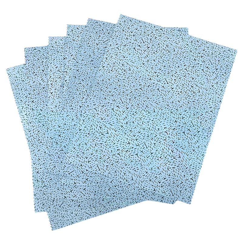 Textured blue oil absorbing wipes with a pattern fanned out on a plain background