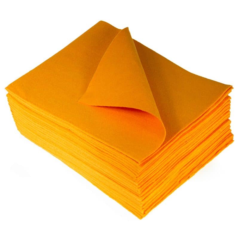 Overhead perspective of a stack of TIDDOX orange liquid absorbent pads with the uppermost cloth gracefully curved to the left against a plain background.